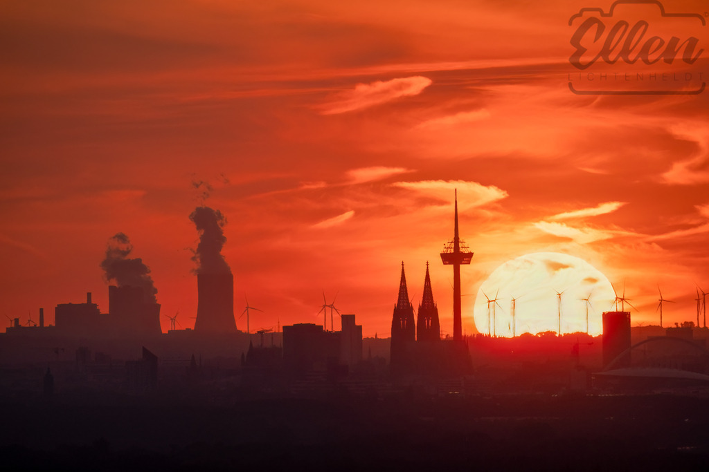 When the Sun Meets the City | As the sun sinks behind Cologne’s skyline, the silhouettes of the cathedral, towers, and wind turbines merge into one breathtaking scene. A moment when the city and the setting sun share the same pulse — glowing, powerful, and fleeting. - Realisiert mit Pictrs.com