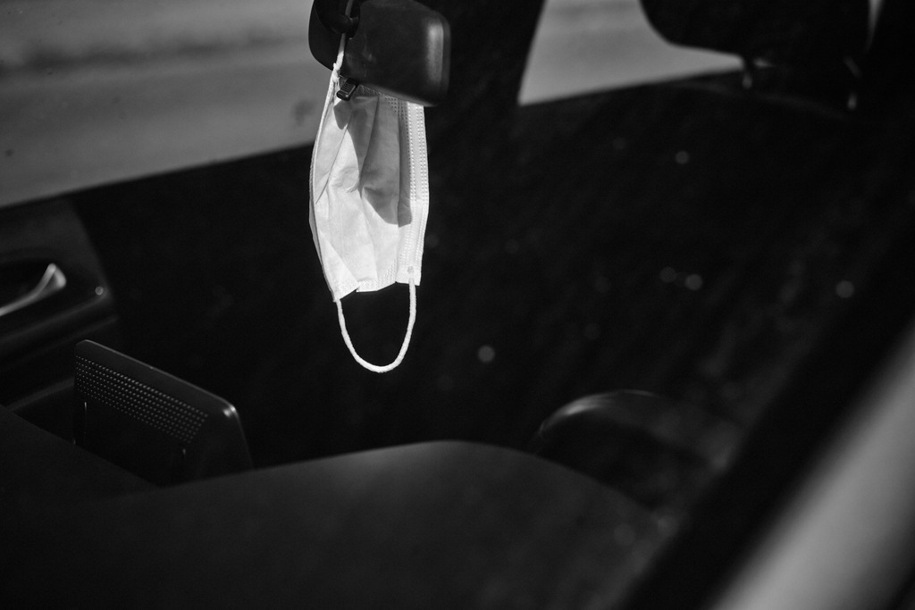 Mundschutzmaske hängt im Auto am Rückspiegel | Wien, Austria - April 05, 2020: Massnahmen zur Einschränkung von COVID-19; Mundschutzmaske hängt im Auto am Rückspiegel. - Realisiert mit Pictrs.com