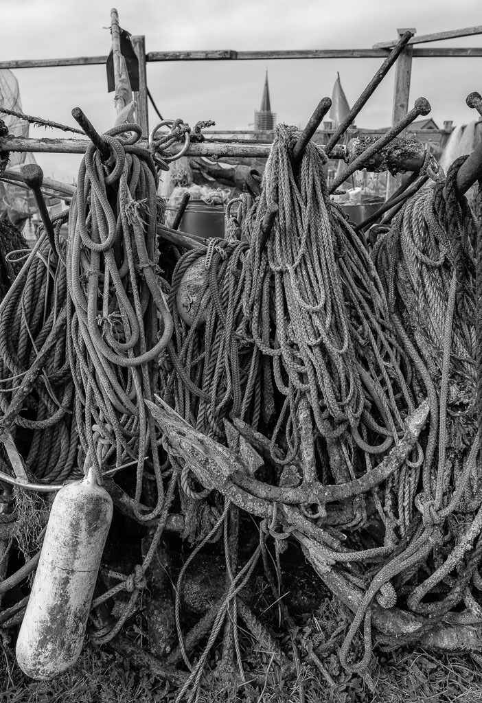 fischer-2020-018 | Die Landungsbrücken am Holmer Strand sind grasbewachsene Anleger der Schleswiger Fischer. Hier machen sie seit Jahrhunderten ihre Boote fest und lagern ihr Material wie diese Anker, Taue und Fender. - Realisiert mit Pictrs.com