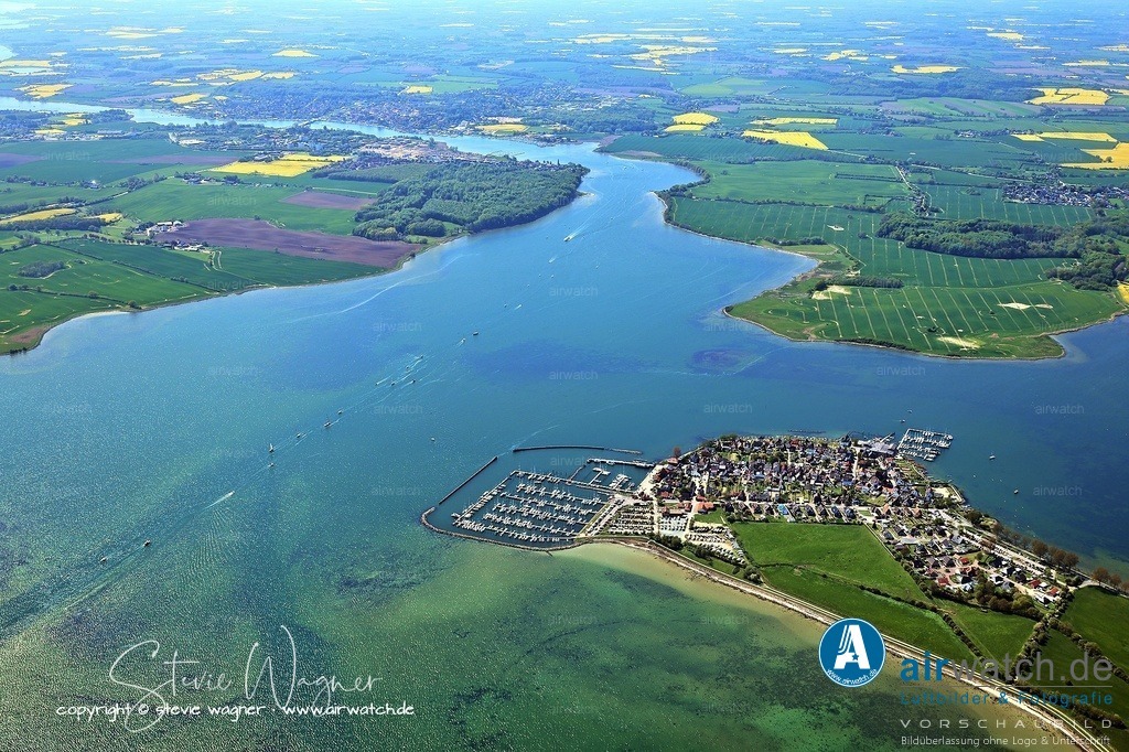 Luftbilder Ostseefjord Schlei, Maasholm, Port Olpenitz, Schleimünde | Die Anfahrt zum Yachthafen Maasholm erfolgt über das Hauptfahrwasser der Schlei. Aus Richtung Ostsee folgt man dem gut markierten Fahrwasser bis zur grün-roten Tonne 15/Maasholm 2, wo man bei 90° in Richtung Hafen abdreht. Die Ansteuerung ist bei Tag und Nacht möglich, da die Hafeneinfahrt befeuert ist. Bei starkem Westwind kann es zu Strömungen kommen, weshalb Abkürzungen über flache Bereiche vermieden werden sollten, um Grundberührungen zu vermeiden.