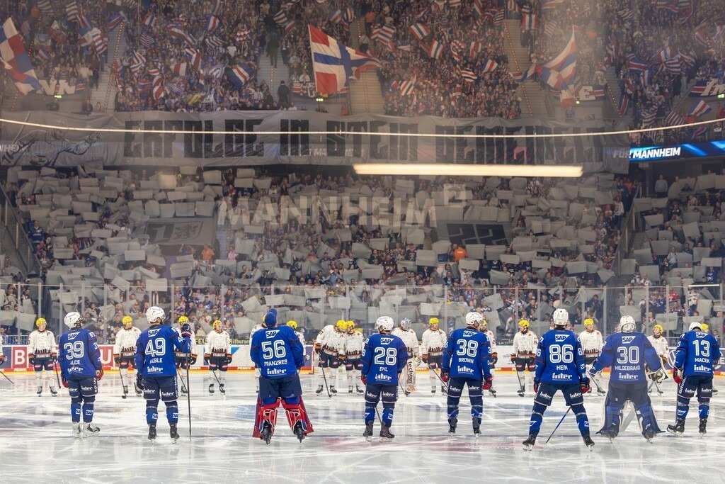 DEL, Deutsche Eishockey Liga Saison 2026/27, 11. Spieltag: Adler Mannheim gegen Löwen Frankfurt | DEL, Deutsche Eishockey Liga Saison 2026/27, 11. Spieltag: Adler Mannheim gegen Löwen Frankfurt / Die Spieler der Adler Mannheim und der Löwen Frankfurt stehen sich kurz vor Spielbeginn gegenüber, im Hintergrund zeigen Fans der Adler eine große Choreografie - Realisiert mit Pictrs.com