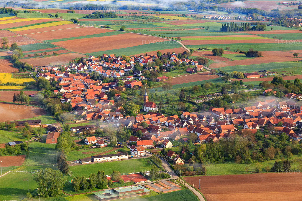 Aerial view: Cemetery and Protestant Church of Hunspach on the southeastern edge of the village in Hunspach in the state Bas-Rhin, France.Photo: IMG_113827.jpg taken on 04/29/2019 by Werner Riehm/FLY-FOTO.comResolution of the original: 5370 x 3580 pxParoisses Protestantes du 