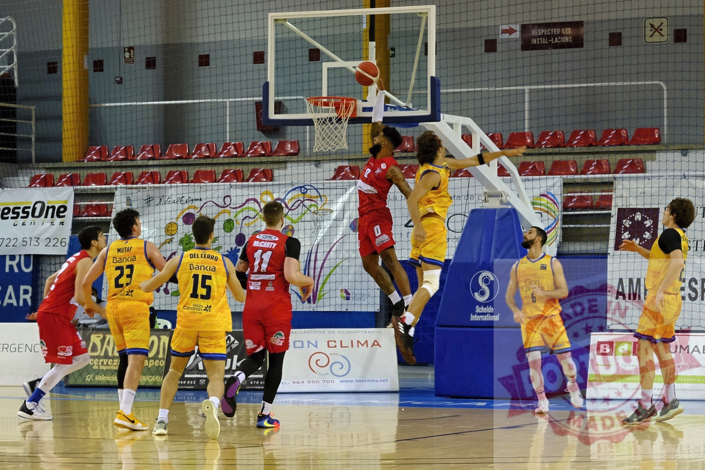 Basketball player scoring a dunk during game | Basketball player in red jersey making a dunk shot on the court during competition - Realized with Pictrs.com