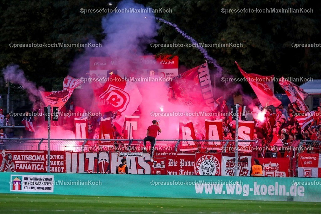 FCVK29082501076 | 29.08.2025, Fußball, FC Viktoria Köln – SSV Jahn Regensburg, 3.Liga, Sportpark Höhenberg, Saison 2025 2026: Die Fans von Jahn Regensburg zünden in der zweiten Halbzeit bengalisches Feuer auf der Gästetribüne. Pyrotechnik brennt im Gästeblock. Choreo Choreografie Choreography Feuerwerkskörper Bengalos.  DFB regulations prohibit any use of photographs as image sequences and or quasi-video.