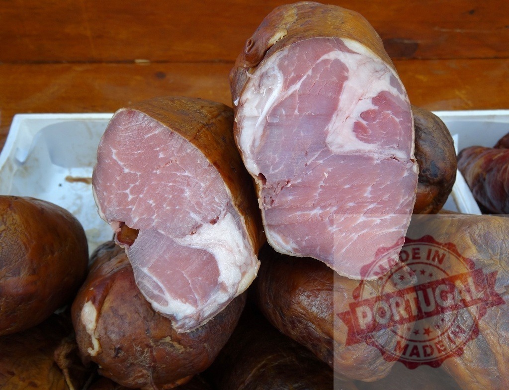 Smoked ham displaying pink meat and fat | Smoked ham cut in half displaying pink meat and white fat at a market stall - Realized with Pictrs.com