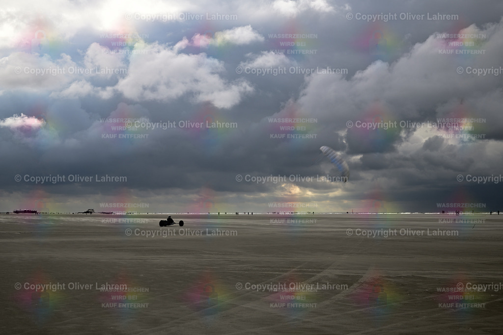 Kite Buggy rasen über den Strand | Ein Kite Buggy rast über den flachen Strand von Sankt Peter Ording und am Himmel wehen düstere Wolken
