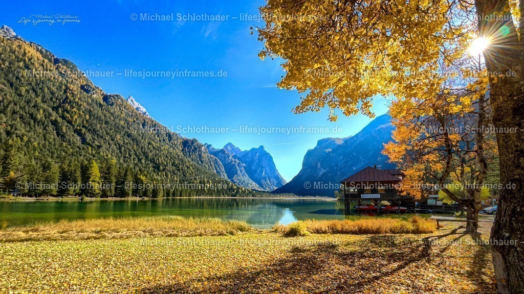 Herbst am Toblacher See | Goldene HerbstblÃ¤tter rahmen den tÃ¼rkisfarbenen Toblacher See vor den Dolomiten â€“ klarer blauer Himmel und Bergpanorama im Hintergrund. - Realisiert mit Pictrs.com