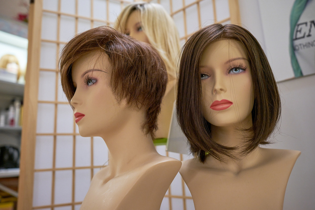 verschiedene Puppenköpfe mit Perücken im Spiegel | WIen, Austria - February 02, 2023; Star Perückensalon GmbH.; verschiedene Puppenköpfe mit Perücken. - Realisiert mit Pictrs.com