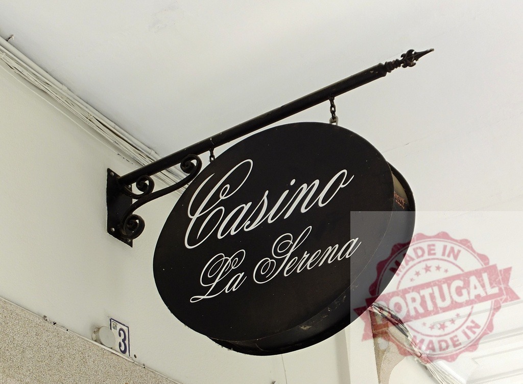 Casino La Serena black oval hanging sign | Casino La Serena vintage oval sign hanging from a building exterior in Europe - Realized with Pictrs.com