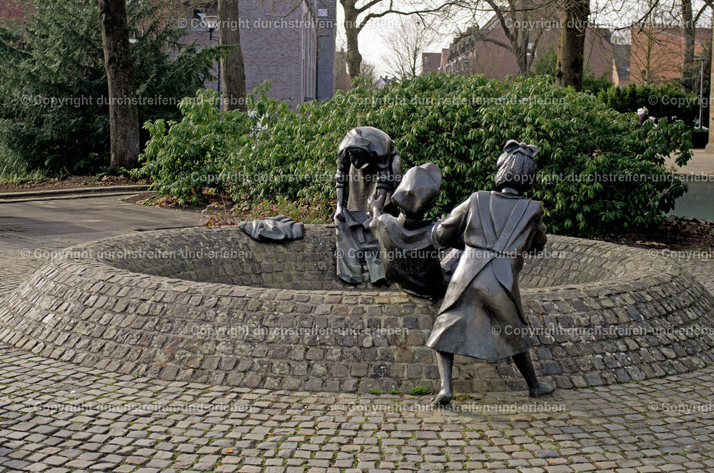 Hiltruper Brunnen „Spielende Kinder“ in Münster | Hiltruper Brunnen „Spielende Kinder“: Die Brunnenanlage befindet sich in unmittelbarer Nähe zur neuen Clemenskirche an der Marktallee. Die Anlage zeigt lebensgroße Bronzefiguren spielender Kinder, die als Wahrzeichen für das Hiltruper Ortszentrum gelten. - Realisiert mit Pictrs.com