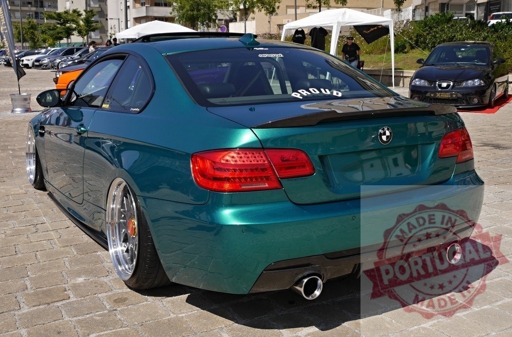 BMW custom coupe lowered with green paint | Custom BMW coupe showcasing its green paint, lowered suspension, and modified exhaust at a car show - Realized with Pictrs.com