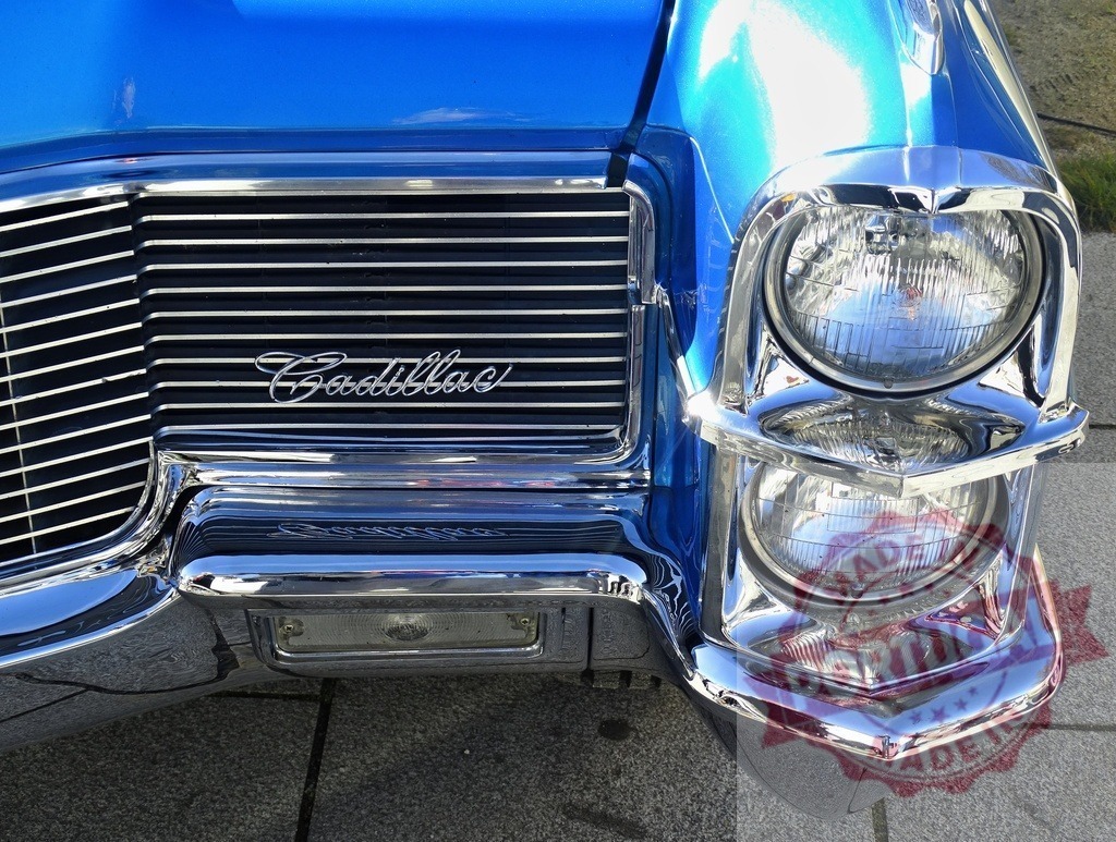 Blue Cadillac classic car front, chrome grille, stacked headlights | Cadillac car front showing vintage design, chrome details, and iconic headlights - Realisiert mit Pictrs.com