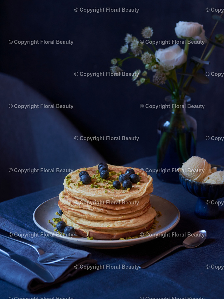Pancakes mit Blaubeeren und Ahornsirup | gestapeltet Pancakes mit Blaubeeren, Ahornsirup und Pistazien mit Vanilleeis auf dunkler Tischdecke - Realisiert mit Pictrs.com