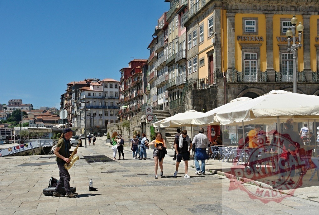 Street musician playing saxophone in historic Porto Ribeira | Street musician playing saxophone for people on Ribeira promenade in Porto - Realisiert mit Pictrs.com