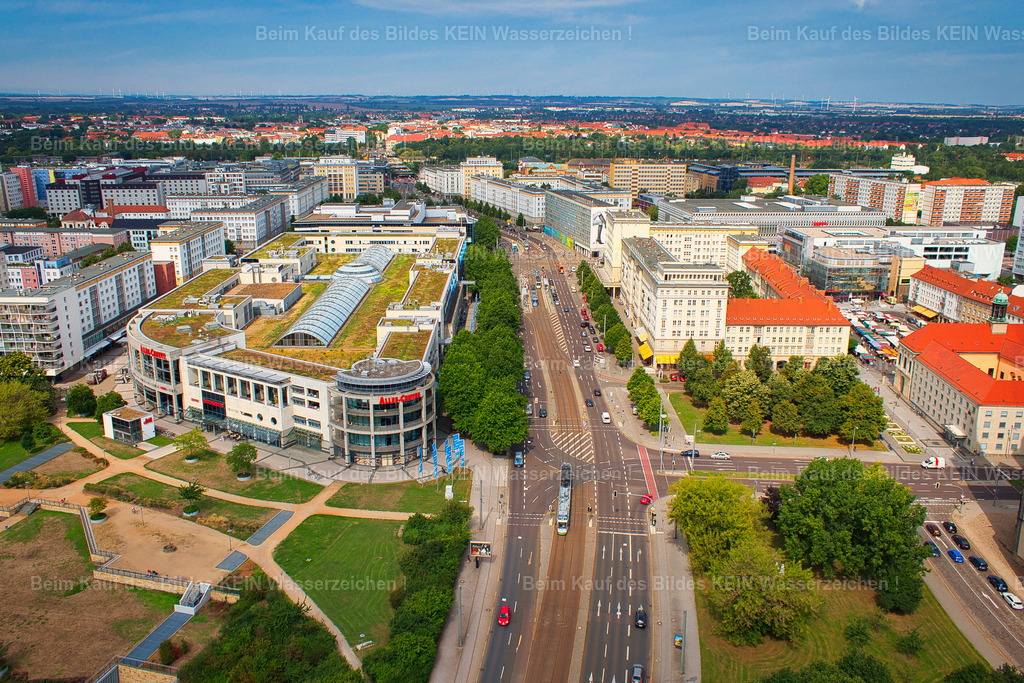 Allee-Center_Ernst-Reuter-Allee-Magdeburg-Luftbild-5042 | Die Ernst-Reuter-Allee zieht sich auf diesem Luftbild fast exakt mittig durch das Motiv und führt den Blick tief in die Magdeburger Innenstadt. Links liegt das Allee-Center, rechts die Bebauung im Bereich der Hartstraße.Heute ist die Ernst-Reuter-Allee eine der wichtigsten Verkehrs- und Geschäftsachsen der Magdeburger Altstadt. Ihr heutiges Gesicht entstand allerdings erst nach der weitgehenden Zerstörung der Innenstadt im Zweiten Weltkrieg. Die neue Ost-West-Achse wurde als repräsentative Hauptstraße des sozialistischen Wiederaufbaus angelegt und zunächst als Stalinallee, später als Wilhelm-Pieck-Allee bezeichnet. Seit 1992 trägt sie den Namen Ernst-Reuter-Allee.Interessant wird der Blick aus der Luft durch den Gegensatz zwischen dieser bewusst neu angelegten breiten Achse und den älteren Straßenstrukturen ringsum. Die Hartstraße beispielsweise reicht mit ihrer Geschichte bis ins Mittelalter zurück und wurde bereits 1425 urkundlich erwähnt. Ihr südlicher Teil wurde beim Bau der heutigen Ernst-Reuter-Allee überbaut. So erzählt dieses scheinbar einfache Luftbild von einem tiefgreifenden Wandel: Eine historische Stadtstruktur wurde zerstört, eine völlig neue Magistrale geschaffen und später wiederum durch moderne Gebäude wie das Allee-Center ergänzt.Ein Blick mitten durch Magdeburg – und gleichzeitig ein Blick auf die Geschichte, die unter und neben dieser Straße weiterlebt. - Realisiert mit Pictrs.com