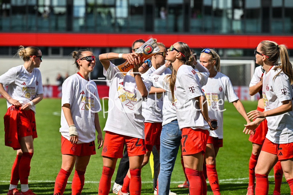 FC Bayern München - SC Freiburg | Die Spielerinnen des FC Bayern feiern die Meisterschaft nach dem Heimsieg gegen den SC Freiburg / Frauen Bundesliga: FC Bayern Muenchen - SC Freiburg, FC Bayern Campus am 27.04.2025 / Arianna CARUSO (FC Bayern Muenchen Frauen 27) gibt Klara BUEHL (FCB #17) einen Schluck auf dem Paulaner Bierkrug / Bierglas