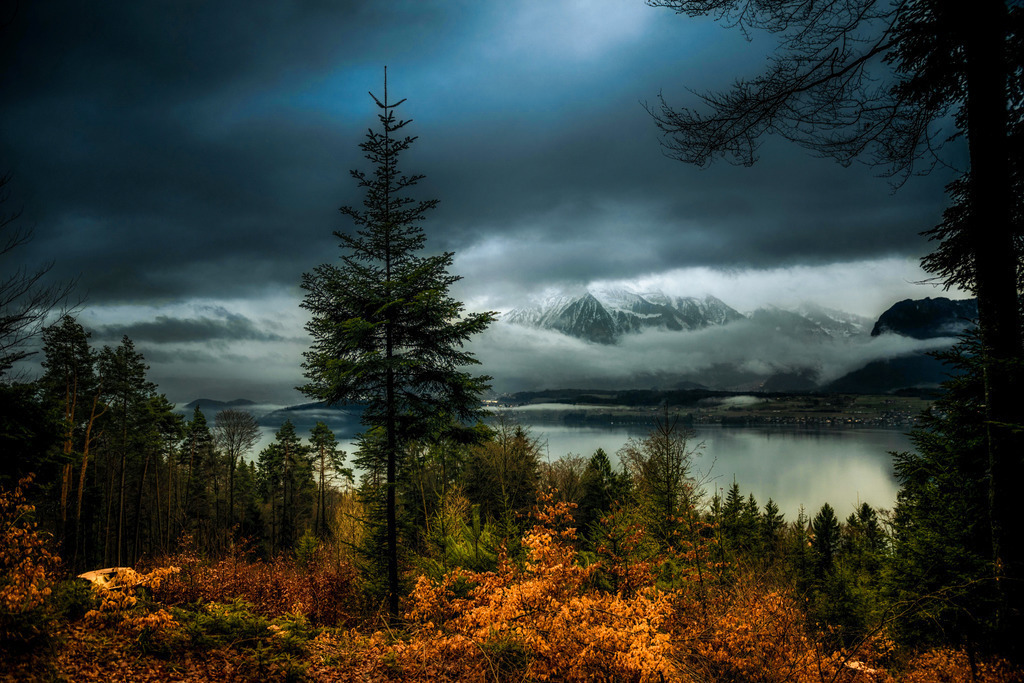 Dämmerung | Dusk | Abenddämmerung im Hilterfinger Wald mit Sicht auf den Thunersee und durch ein Wolkenfenster auf den Niesen. 
-----------------------------------------------
Dusk in the Hilterfinger Forest with a view of Lake Thun and the Niesen through a cloud window.
-----------------------------------------------
Dieser Druck ist in einer limitierten Auflage von 5 Exemplaren erhältlich. 
This print is available in a limited edition of 5 copies. 
http://art.hess.photography/20-daemmerung.html - Realisiert mit Pictrs.com