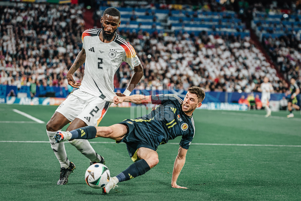 Fußball | Herren | UEFA-Fußball-Europameisterschaft 2024 | MD1 | Gruppe A | Deutschland vs. Schottland | 14.06.2024 | v.l. Antonio Rüdiger (#2, Deutschland) und Ryan Christie (#11, Schottland) kämpfen um den Ball