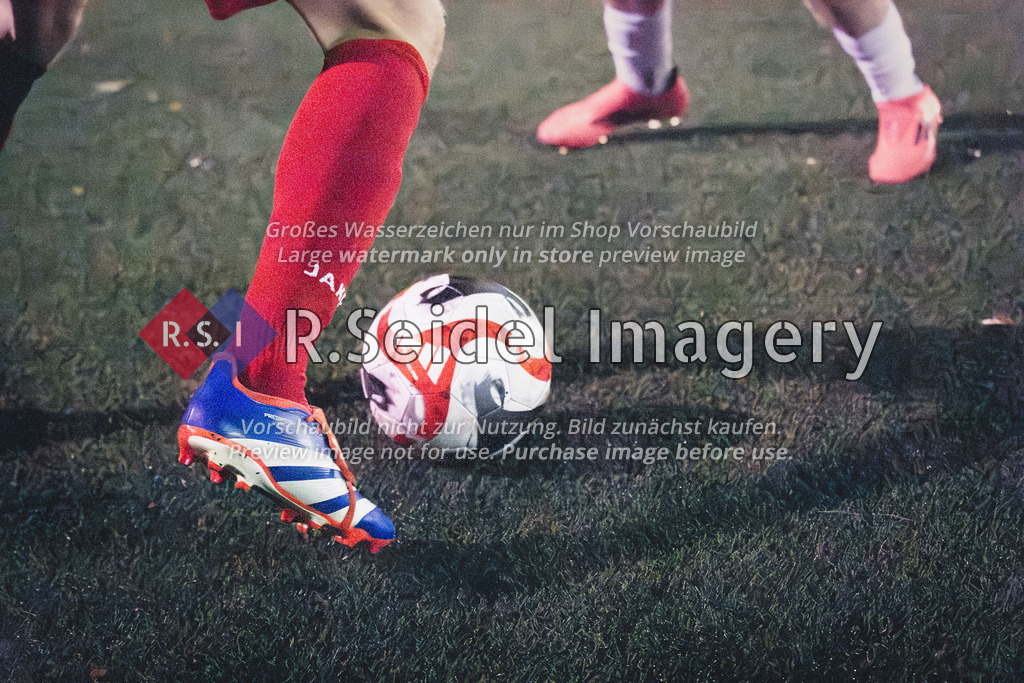 RS-1-076345 | Fußballer am Ball auf Kunstrasen nachts unter Flutlicht – Nahaufnahme der Beine in roten Jako Stutzen und blauen Adidas Predator League Schuhen mit orangen und weißen Akzenten