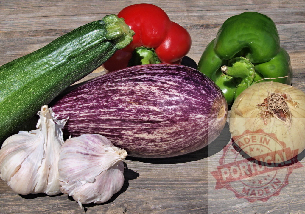Fresh organic garden vegetables harvested for healthy eating | Assortment of zucchini, eggplant, peppers, onion, and garlic on a wooden table - Realized with Pictrs.com