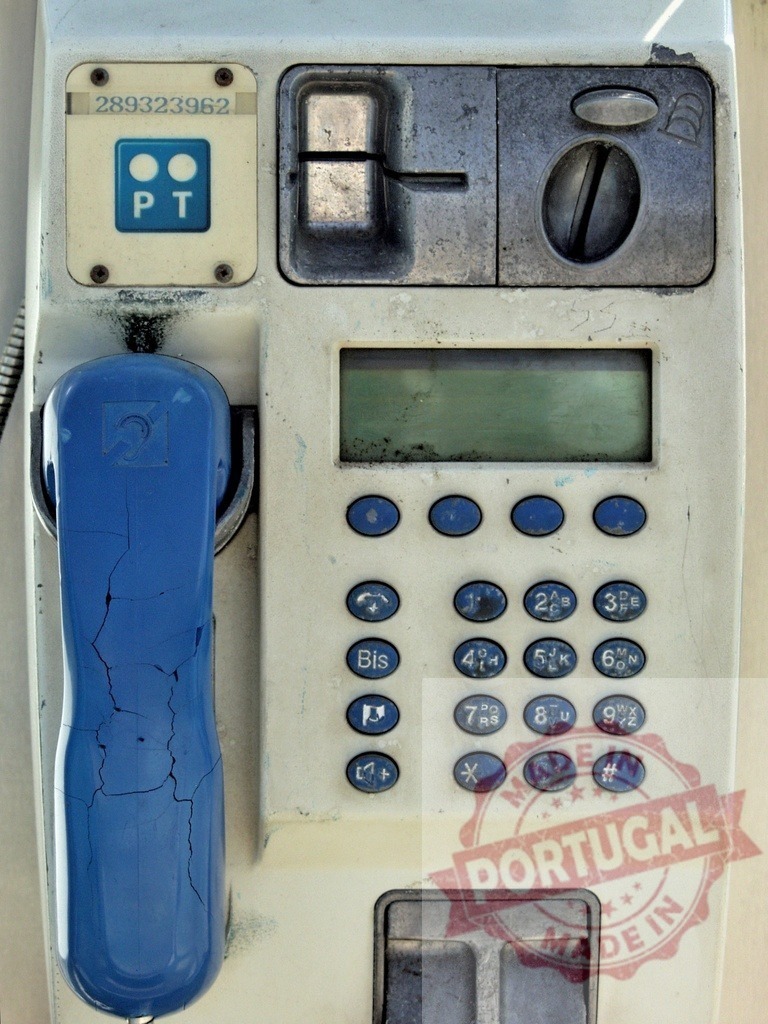 Old broken public telephone showing signs of decay and abandonment | Close-up of a weathered and cracked public pay phone, highlighting its obsolescence in the modern communication era - Realized with Pictrs.com