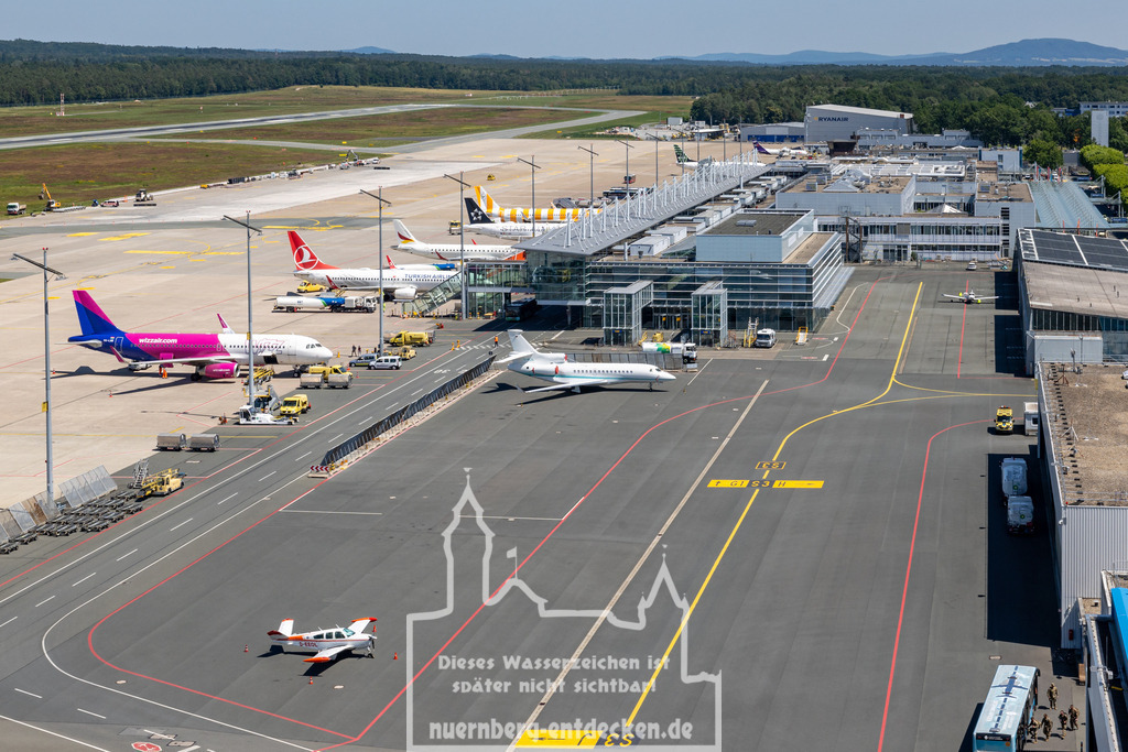 Nürnberger Flughafen | Das Terminalgebäude und Vorfeld des Albrecht-Dürer-Flughafens Nürnberg mit Flugzeugen verschiedener Fluggesellschaften. In Nürnberg findet ein gemischter kommerzieller Flugbetrieb sowie Privat- und Geschäftsflugverkehr statt. - Realisiert mit Pictrs.com