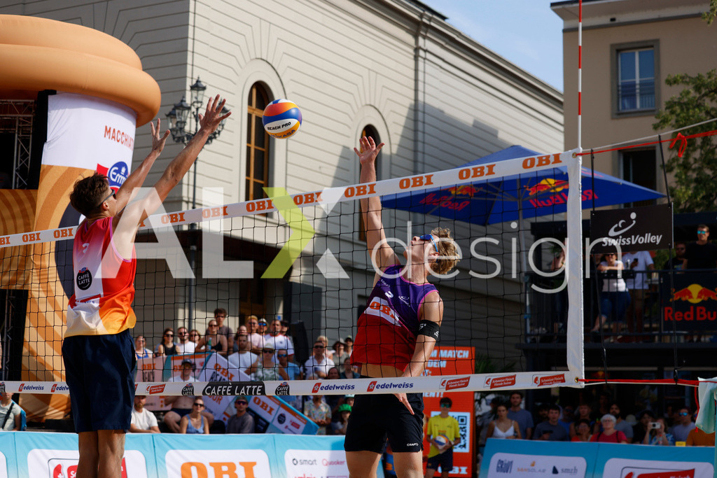 Obi BeachTour 2026 - Basel | BASEL, SWITZERLAND - JULY 19: MATHIS KÄLIN (SUI) attack / spike against LUC EMANUEL FLÜCKIGER (SUI) block during the Obi BeachTour 2026 match between DILLIER / FLÜCKIGER (SUI) and BREER / KÄLIN (SUI) at Barfüsserplatz on July 19, 2026 in Basel, Switzerland. - Realisiert mit Pictrs.com
