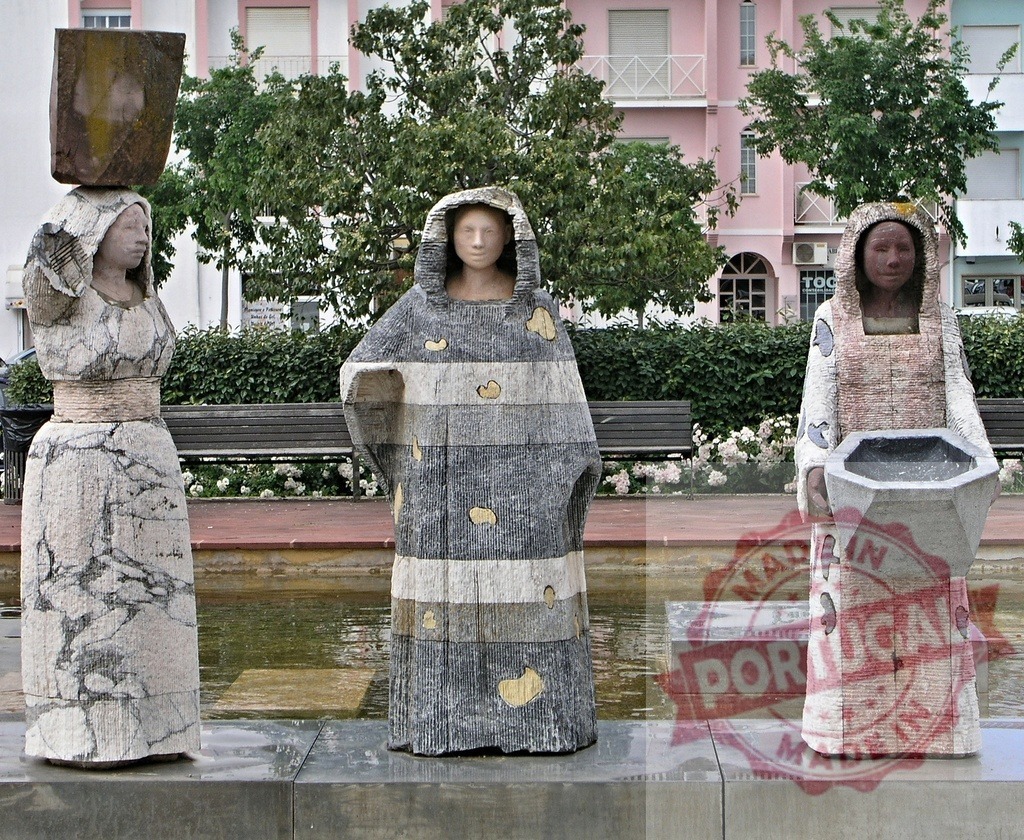 Stone women sculptures creating a fountain in urban garden. Algarve - Silves | Stone women sculptures in a contemporary fountain surrounded by an urban garden - Realisiert mit Pictrs.com