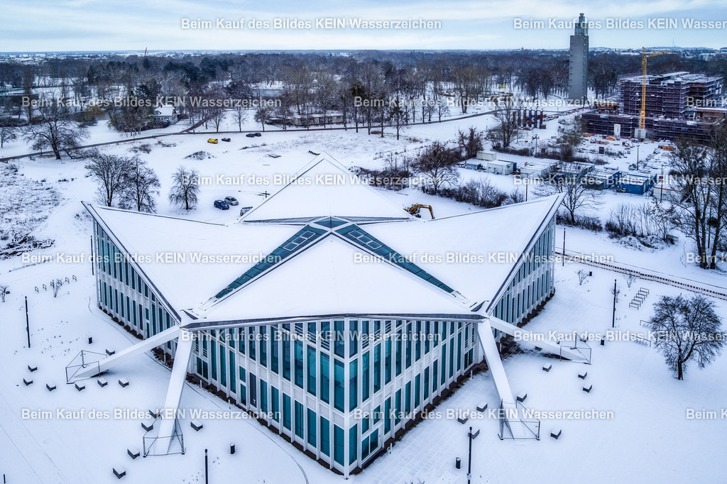 Hyparschale im Schnee-0032 | Luftbild der Hyparschale in der Landeshauptstadt Magdeburg in Sachsen-Anhalt im Winter. Die markante Dachkonstruktion hebt sich deutlich von der winterlichen Parklandschaft und der Umgebung ab. - Realisiert mit Pictrs.com