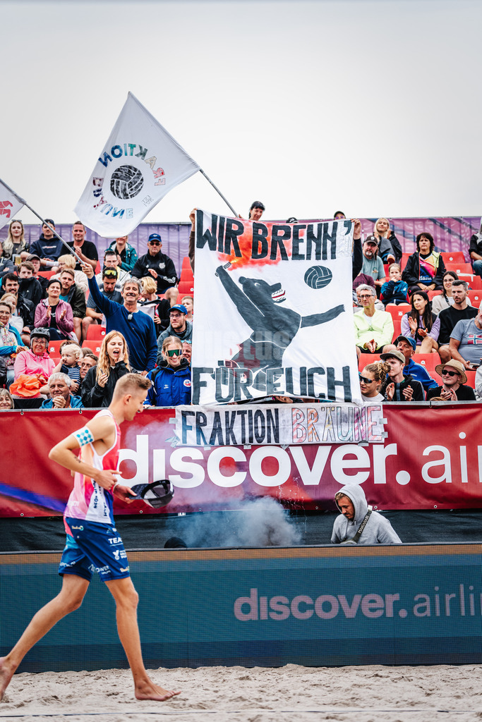 Beachvolleyball | Männer | Allianz German Beach Tour 2024 | Tourstop Kühlungsborn 2 | 18.08.2024 | Während Momme Lorenz in das Stadion einläuft, hält die 'Fraktion Bräune' ein Banner mit der Aufschrift: Wir Brenn Für Euch'