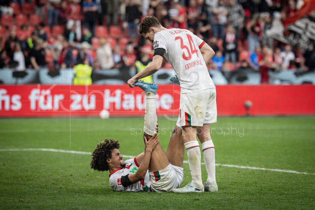 German Bundesliga, Bayer 04 Leverkusen vs. FC Augsburg, 18.04.2026 | LEVERKUSEN, GERMANY - APRIL 18, 2026 :  Han-Noah Massengo (FC Augsburg, 4) has a cramp after the game, +34+ is helping him during the German Bundesliga match on gameday 30 between Bayer 04 Leverkusen vs. FC Augsburg at BayArena on April 18, 2026 in Leverkusen, Germany. DFL REGULATIONS PROHIBIT ANY USE OF PHOTOGRAPHS AS IMAGE SEQUENCES AND/OR QUASI-VIDEO.