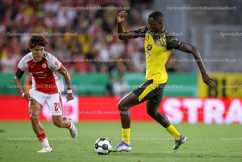 DFB18082501055 | 2025.08.18, Fußball, 1.Runde DFB-Pokal, Rot-Weiss Essen - Borussia Dortmund, Stadion Hafenstraße, Saison 2025 2026: Kaito Mizuta&nbsp;(Rot-Weiss Essen #24) im Zweikampf gegen  Serhou Guirassy&nbsp;(BVB #09)  DFB regulations prohibit any use of photographs as image sequences and or quasi-video.