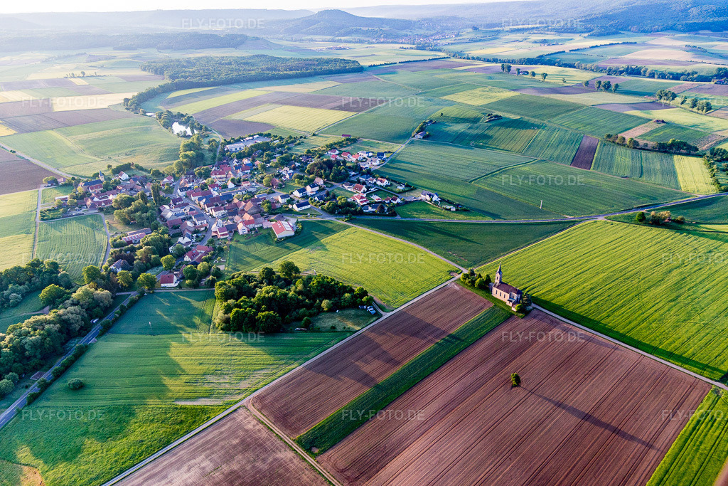 Luftbild: Landwirtschaftliche Nutzflächen und Feldgrenzen umsäumen das Siedlungsgebiet des Dorfes im Ortsteil Bischwind in Dingolshausen im Bundesland Bayern in Deutschland. Foto: IMG_107202.jpg vom 10.05.2018 durch Werner Riehm/FLY-FOTO.de
