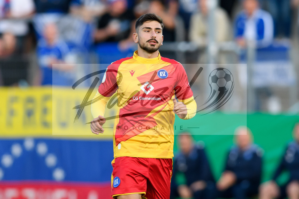 LOTKSC20210809_241 | Fussball, Herren: Malik Batmaz (Karlsruher SC) schaut beim Spiel der 1. Runde im DFB-Pokal zwischen SF Lotte und Karlsruher SC im Stadion am Lotter Kreuz am 09.08.2021 in Lotte, Deutschland.DFB / DFL REGULATIONS PROHIBIT ANY USE OF PHOTOGRAPHS AS IMAGE SEQUENCES AND/OR QUASI-VIDEO. - Realisiert mit Pictrs.com