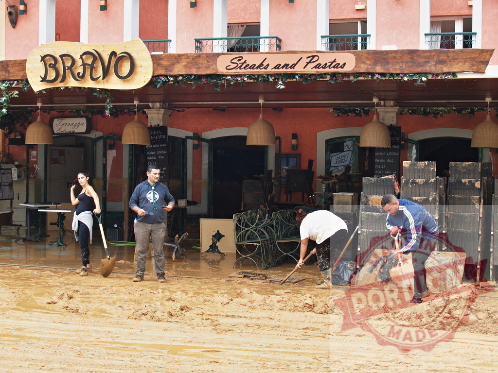 Community cleaning mud after devastating flood disaster | Albufeira Flood - discruction by weather problems People clearing mud from outside a restaurant after a natural disaster - Realisiert mit Pictrs.com