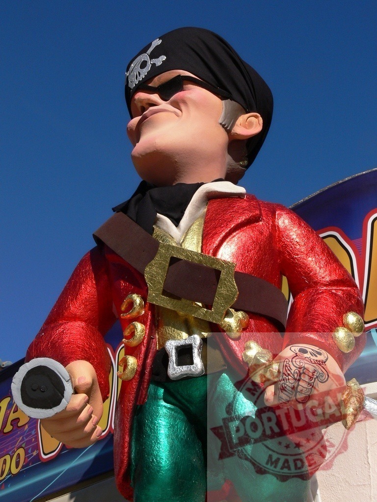 Pirate statue wearing a red coat and bandanna with skull emblem | Pirate caricature statue representing adventurous spirit and fun - Realized with Pictrs.com