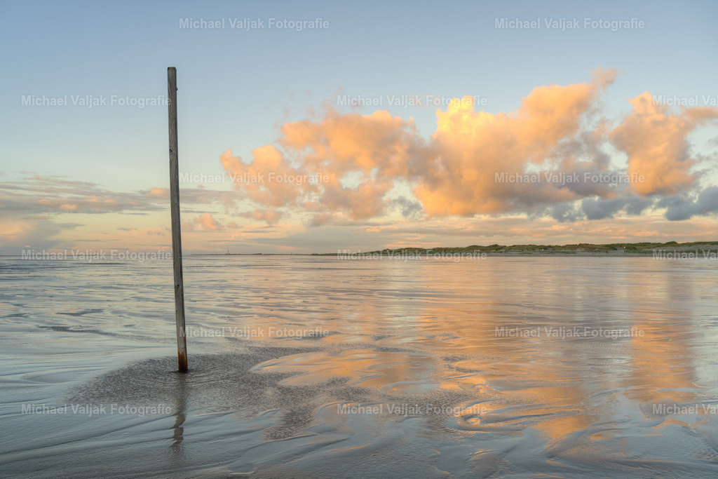 Abends am Strand in Sankt Peter-Ording | Nach einem verregneten Tag am Strand in Sankt Peter-Ording lockert sich die Bewölkung am Abend etwas auf und die Sonne leuchtet die Wolken bunt an.  - Realisiert mit Pictrs.com