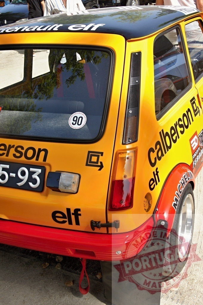 Renault 5 Turbo rally car racing on track | Yellow Renault 5 Turbo vintage racing car displaying sponsors and competition number - Realized with Pictrs.com