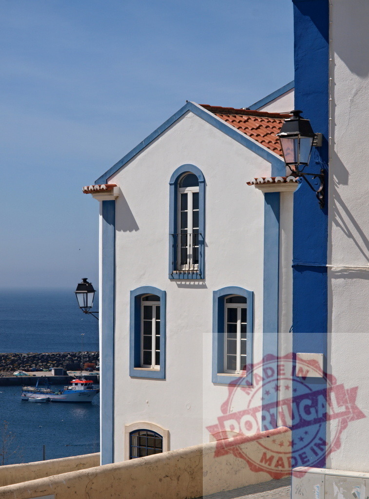 Traditional Portuguese house overlooking the harbor in Ericeira | White and blue facade of a house in a coastal town, with the Atlantic Ocean and harbor in the background - Realisiert mit Pictrs.com
