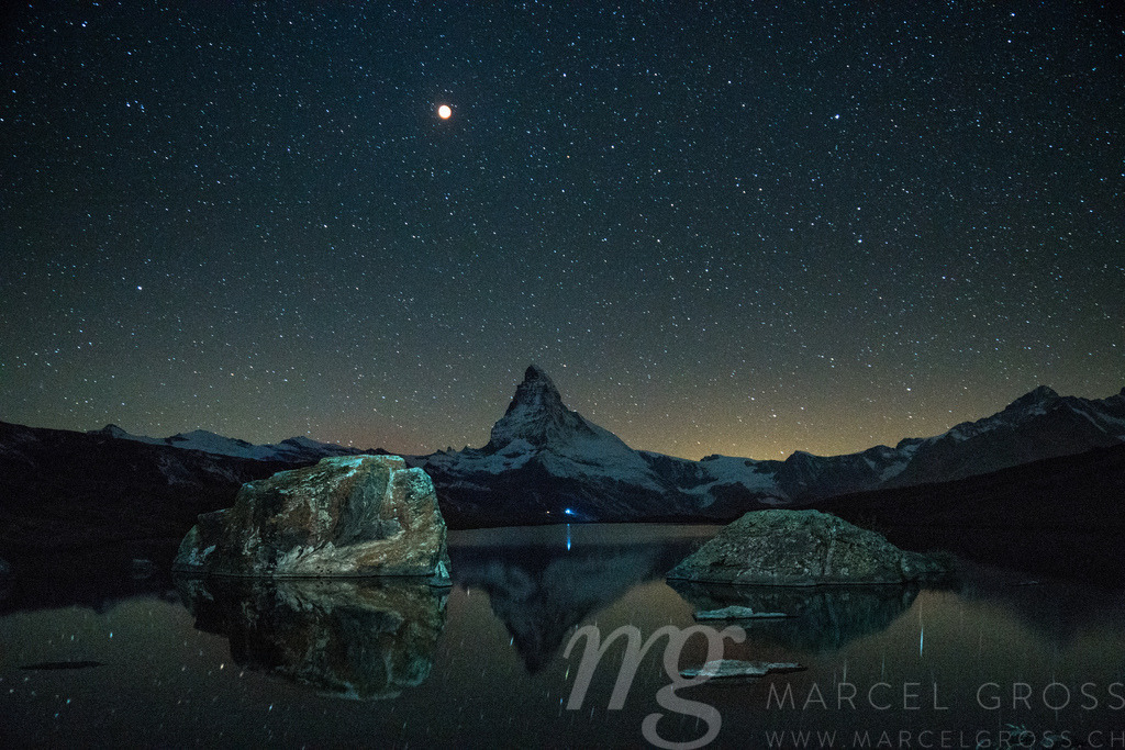 Matterhorn at blood moon with reflection in alpine lake | Die ideale Geschenkidee für Naturliebhaber. Naturbilder von Marcel Gross Photography für ihr Zuhause in den verschiedensten Formaten und Materialien. - Realisiert mit Pictrs.com