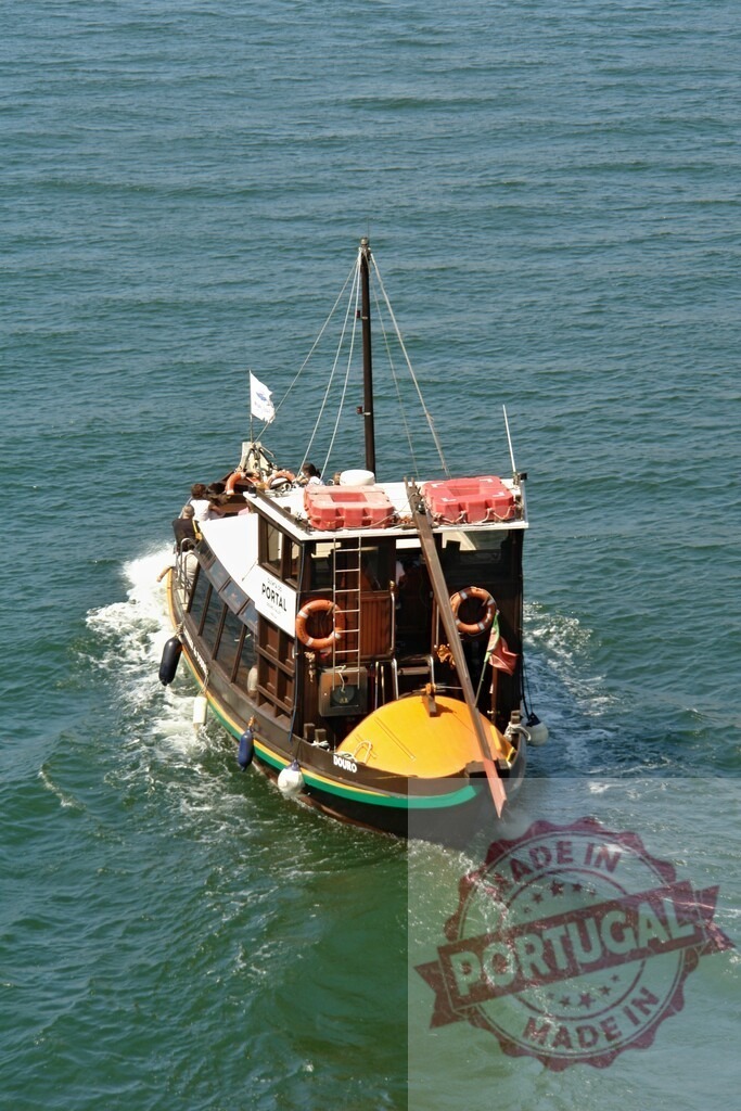 Traditional rabelo boat cruising Douro river in Porto. Porto - Portugal | Traditional rabelo boat moving along the water of Douro river on a sunny day - Realized with Pictrs.com