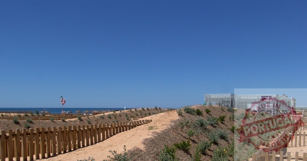 Sandy pathway leading to beach and resort building | Sandy pathway leading to a beach and resort building on a clear sunny day - Realisiert mit Pictrs.com