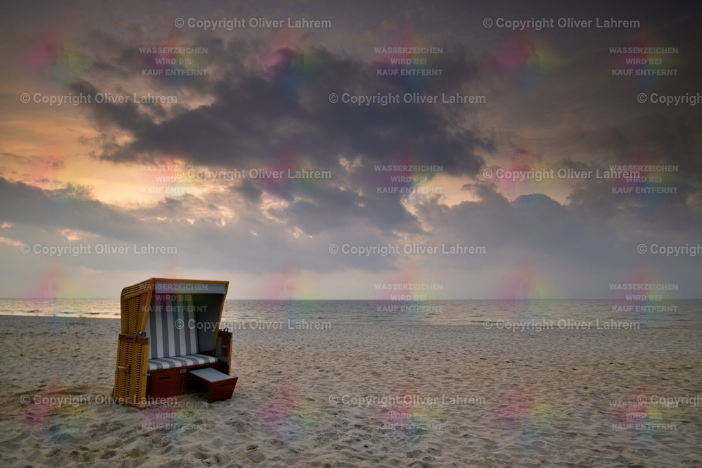 Strandkorb im Abendlicht | Ei Strandkorb steht im Sand und die Wolken am Himmel leuchten im Abendlicht.