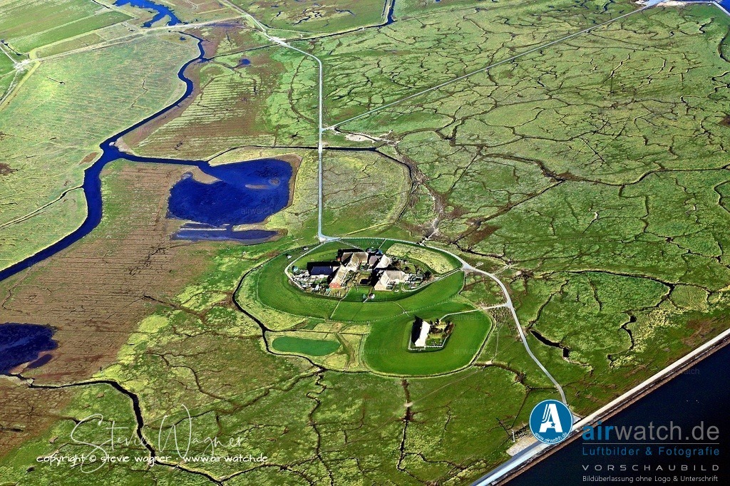 Luftbild Hallig Groede - Die Insel bestand ursprünglich aus zwei Teilen | Die Insel bestand ursprünglich aus zwei Teilen: der bewohnten Hallig Gröde im Süden und der unbewohnten Hallig Appelland im Norden. Um 1900 wurden beide durch einen Damm verbunden, um den Küstenschutz zu verbessern. Diese Maßnahme führte zur Vereinigung der beiden Halligen, wobei der Priel zwischen ihnen bis heute als Grenze sichtbar bleibt.