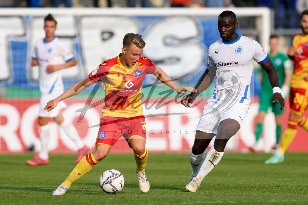 LOTKSC20210809_173 | Fussball, Herren: Marco Thiede (Karlsruher SC) und Exauce Andzouana (Sportfreunde Lotte) im Zweikampf beim Spiel der 1. Runde im DFB-Pokal zwischen SF Lotte und Karlsruher SC im Stadion am Lotter Kreuz am 09.08.2021 in Lotte, Deutschland.DFB / DFL REGULATIONS PROHIBIT ANY USE OF PHOTOGRAPHS AS IMAGE SEQUENCES AND/OR QUASI-VIDEO. - Realisiert mit Pictrs.com