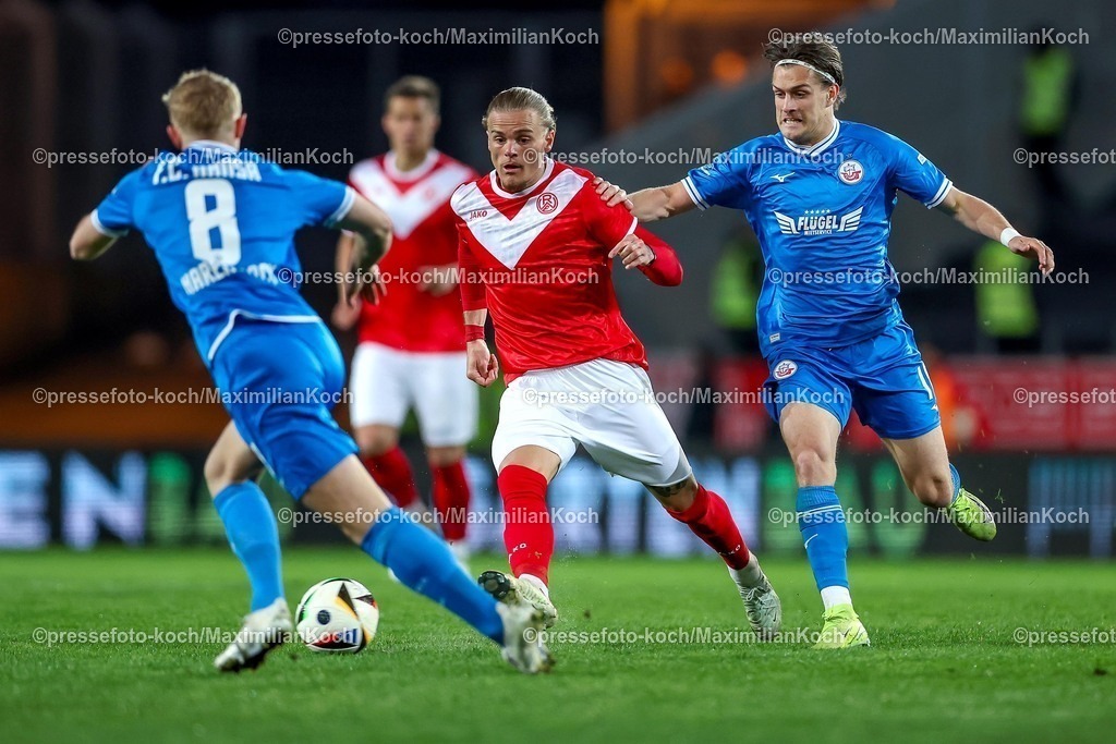 RWE06042501127 | 2025.04.06, Fußball, 3.Liga, Rot-Weiss Essen - FC Hansa Rostock, Stadion Hafenstraße, Saison 2024 2025: Tom Moustier (RWE #28) im Zweikampf gegen Cedric Harenbrock (FC Hansa Rostock #08) und Sigurd Haugen (FC Hansa Rostock #18) DFB regulations prohibit any use of photographs as image sequences and or quasi-video.