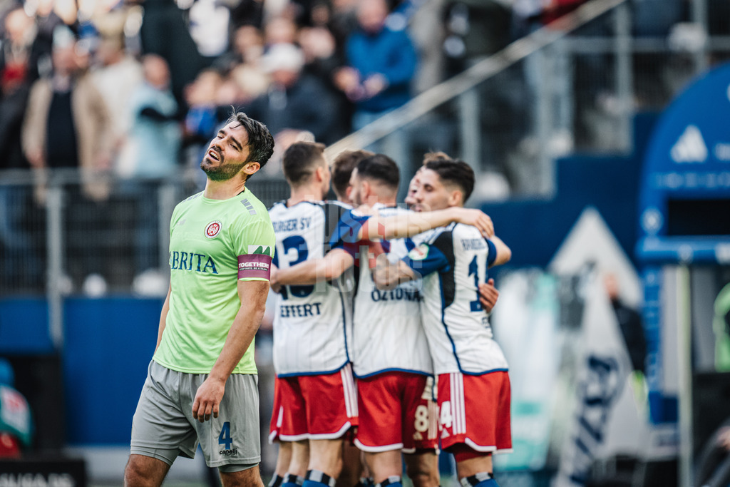 Fußball | Männer | Saison 2023/2024 | 2. Fußball-Bundesliga | 26. Spieltag | Hamburger SV vs. SV Wehen Wiesbaden | 17.03.2024 | Während Torschütze Miro Muheim (#28, HSV) im Hintergrund feiert, ärgert sich Pechvogel Sascha Mockenhaupt (#4, SV Wehen Wiesbaden) im Vordergrund
