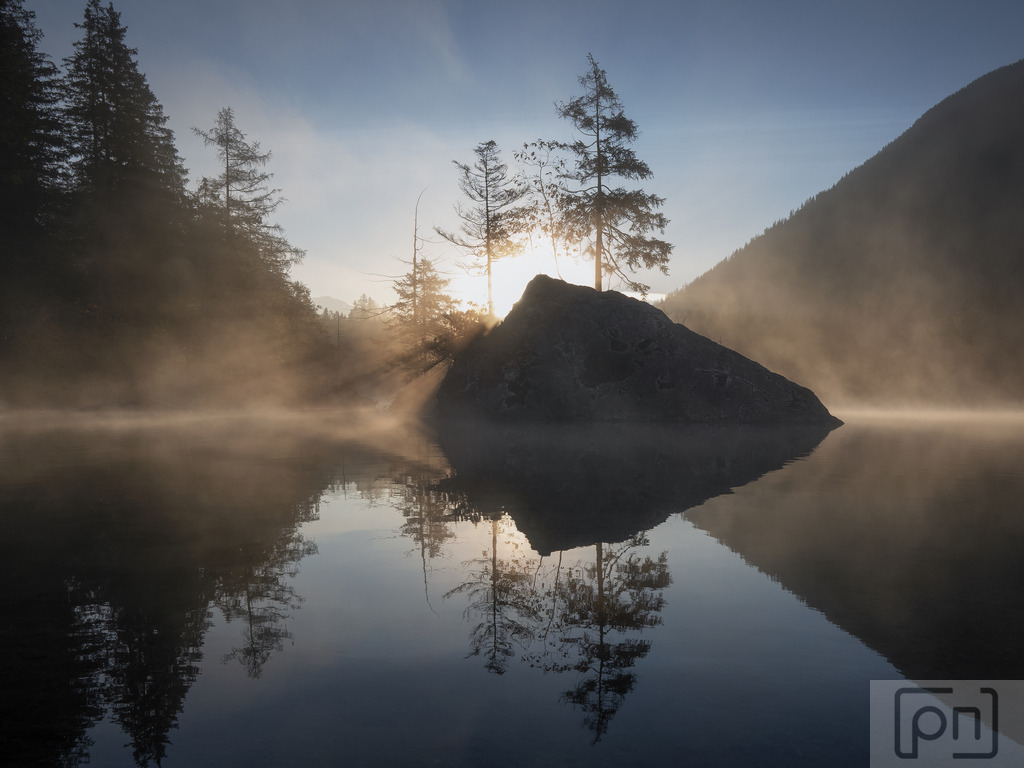  Die erhabene Schönheit | Diese Momente sind für Fotografen ein Traum, da sie die Gelegenheit bieten, die erhabene Schönheit der bayerischen Alpen und des Hintersees in ihrer ganzen Pracht einzufangen. Die Spiegelung der Berge im ruhigen Wasser, die sich langsam bewegenden Nebelschwaden und die friedliche Atmosphäre machen den Hintersee zu einem perfekten Ort für atemberaubende Sonnenaufgangsfotografien.