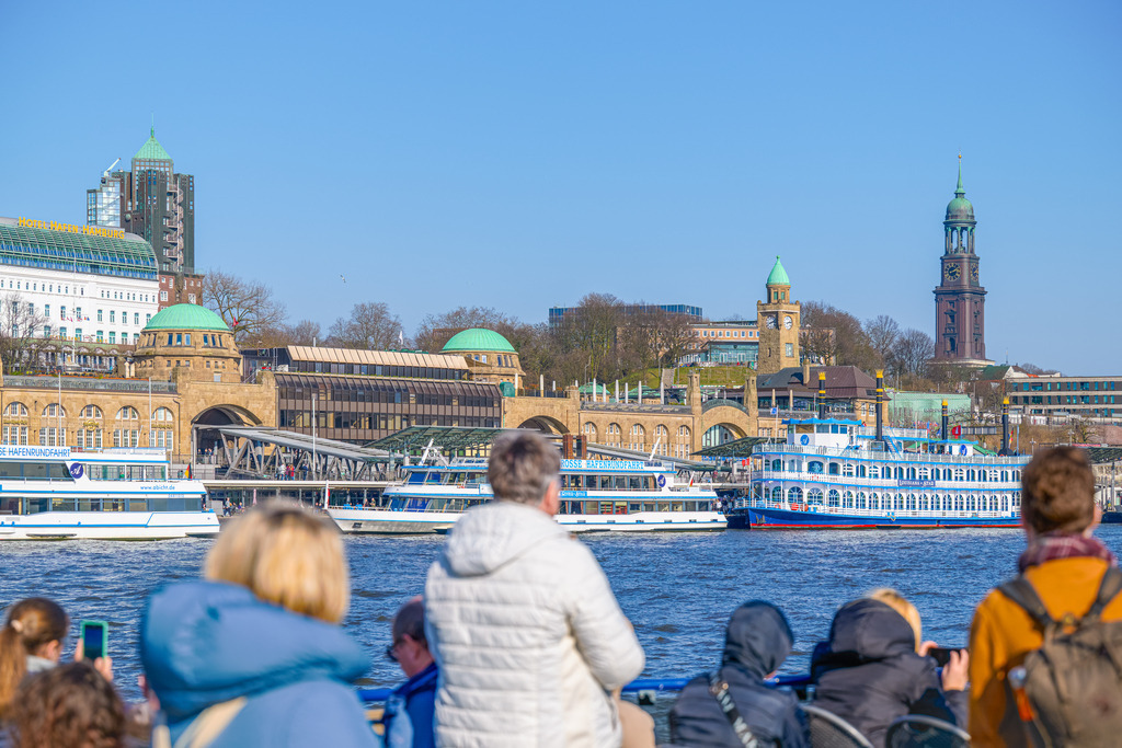 Hafenrundfahrt Landungsbrücken | Fahrgäste schauen von einem Schiff auf die Landungsbrücken in Hamburg. Eine Aufnahme bei strahlendem Sonnenschein im Winterhalbjahr. - Realisiert mit Pictrs.com