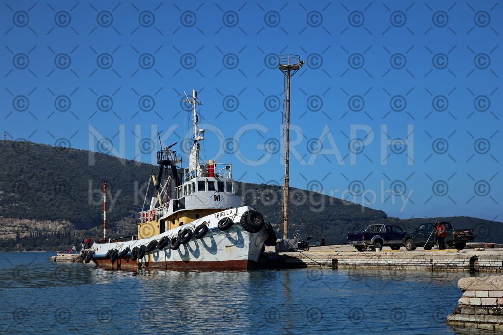 Hafenschlepper Thiella | Der Hafenschlepper Thiella am Hafen von Igoumenitsa. Im Hintergrund erhebt sich die nordgriechische Bergkulisse in den blauen Himmel über dem Mittelmeer.